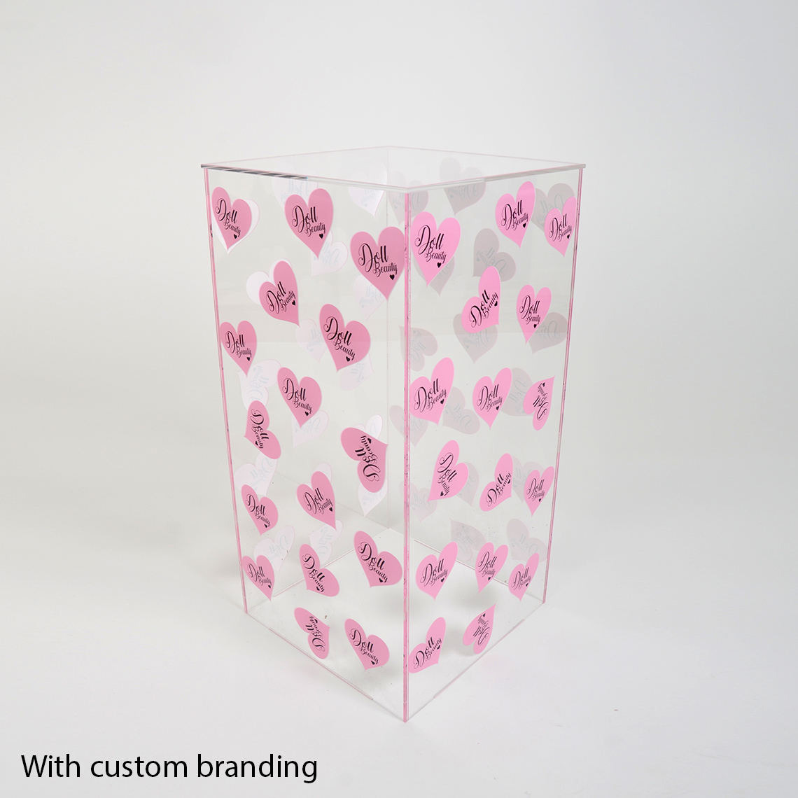 One Clear Acrylic Display Plinth With Custom Branded Pink Hearts Printed Onto The Sides.