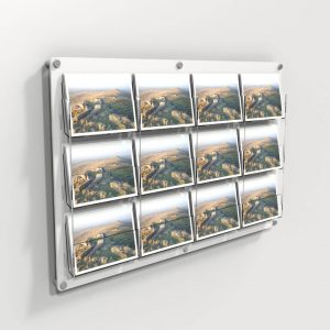 A clear and white wall mounted 12 pocket postcard holder with postcards on display.