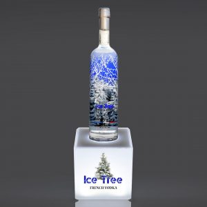 A custom illuminated bottle display with a "ice tree" logo on the base and a bottle of spirits on top of the display.