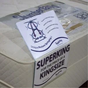 A mattress ticket holder with product information, placed on a mattress.