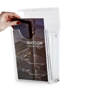 A hand reaching in to take a leaflet from a wall mounted outdoor leaflet dispenser.