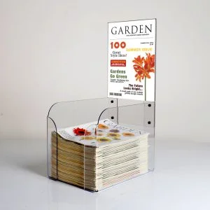 A countertop magazine stand with magazines inside and a header with removeable graphics.
