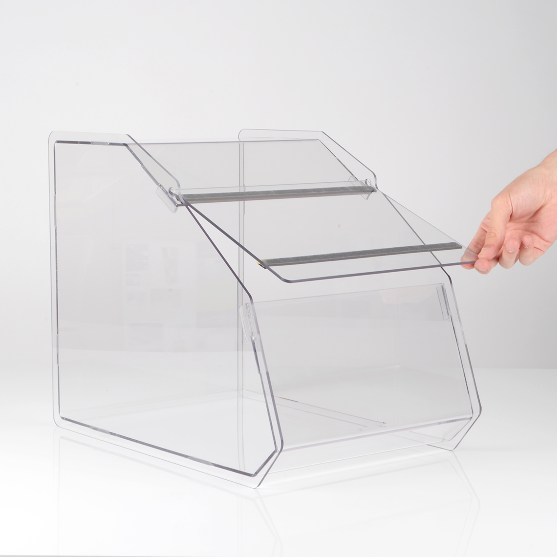 A clear acrylic PETG pet shop food bin with a hand lifting the lid.