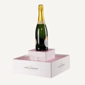 A bespoke pink counter display plinth with a bottle of champagne on top.