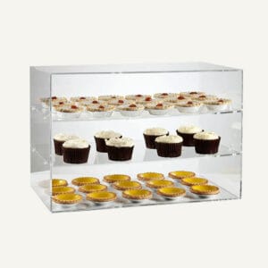 A clear acrylic display unit with three shelves holding a selection of cakes.