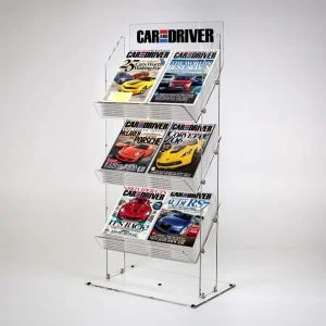 A clear acrylic magazine and newspaper display stand with magazines and a logo.