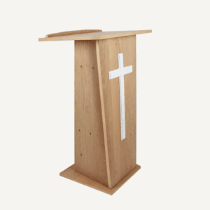A wooden church lectern facing the right with a large white cross on the front.