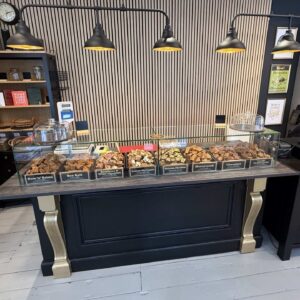 A bespoke glass sneeze guard on a tabletop with fudge on display.