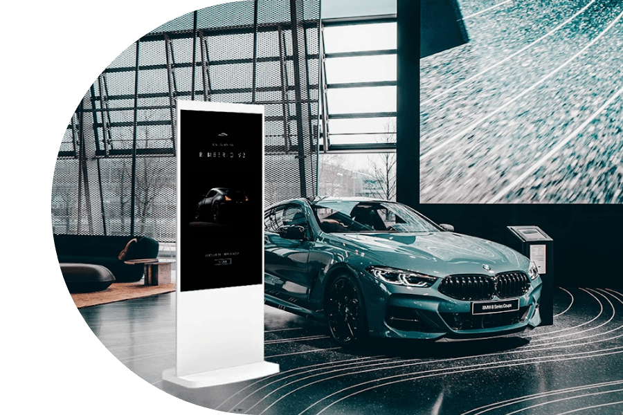 Floor standing white digital screen in car dealership.