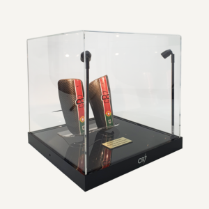 A collectors acrylic display case with spotlights, a black customisable base and personalised plaque, featuring Cristiano Ronaldo’s match-worn shin pads.