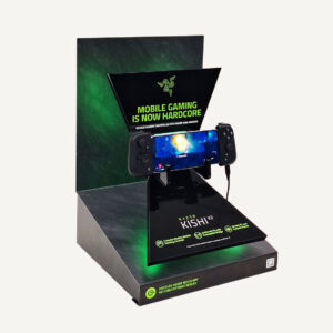 Gaming console display stand featuring the Razer Kishi V2 mobile gaming controller with a mounted smartphone showing gameplay.