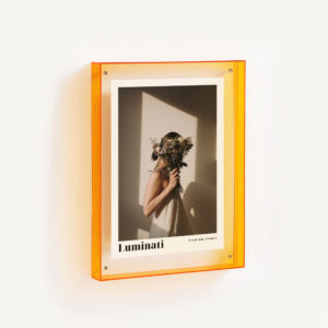 Translucent orange floating frame with fashion print displayed mounted on a wall.