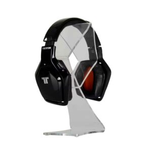 A clear acrylic countertop headphone stand with headphones on display.
