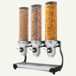 A countertop dispenser with three cylinders with different cereals inside.