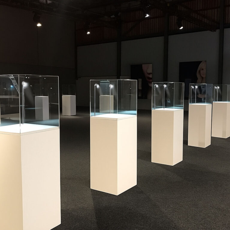 White Display Plinth Pedestals with clear display case on top and LED spot light in an exhibition studio.