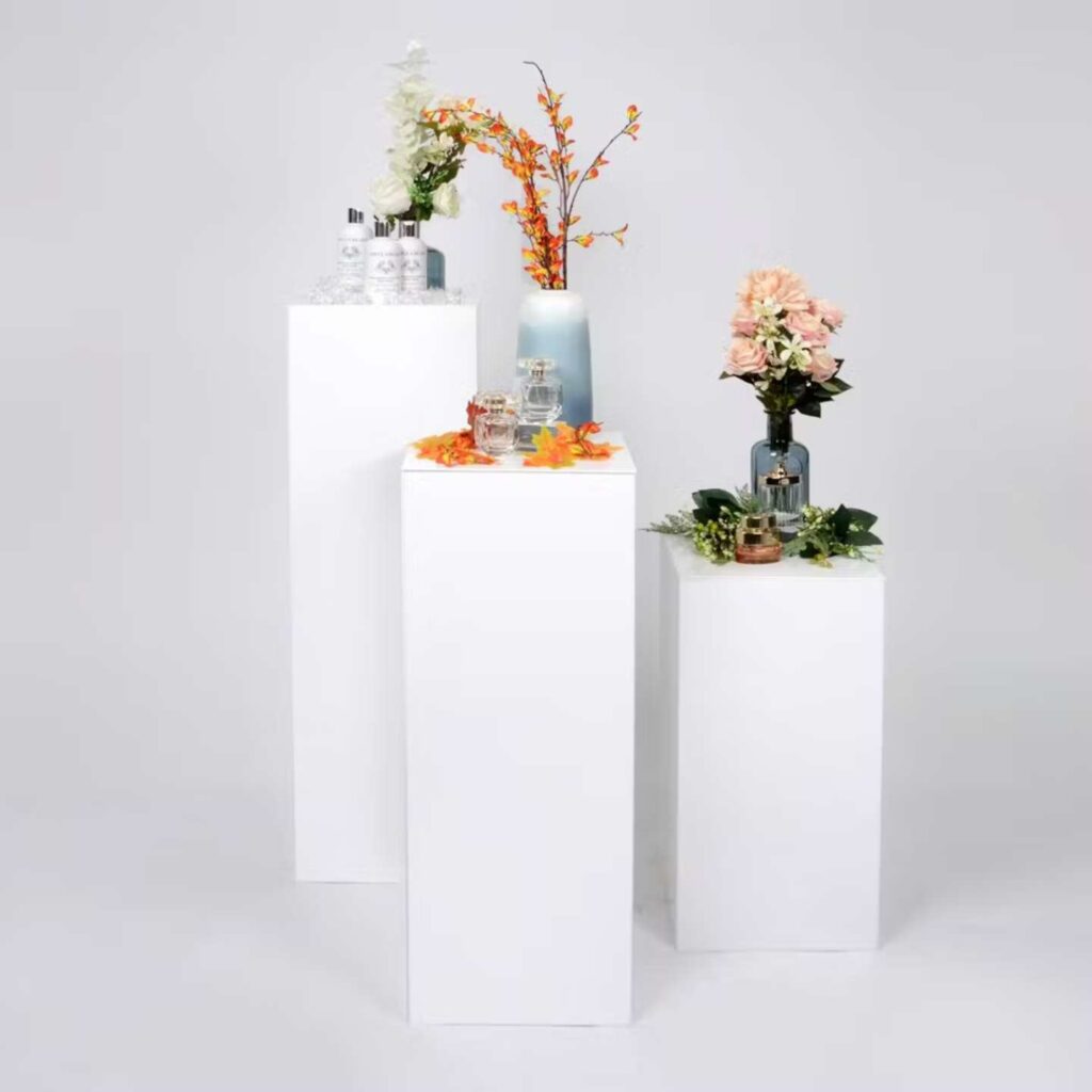 Three white plinths with products on top.