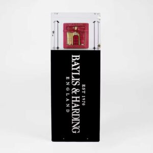 A branded, illuminated plinth with a lock and products on display.