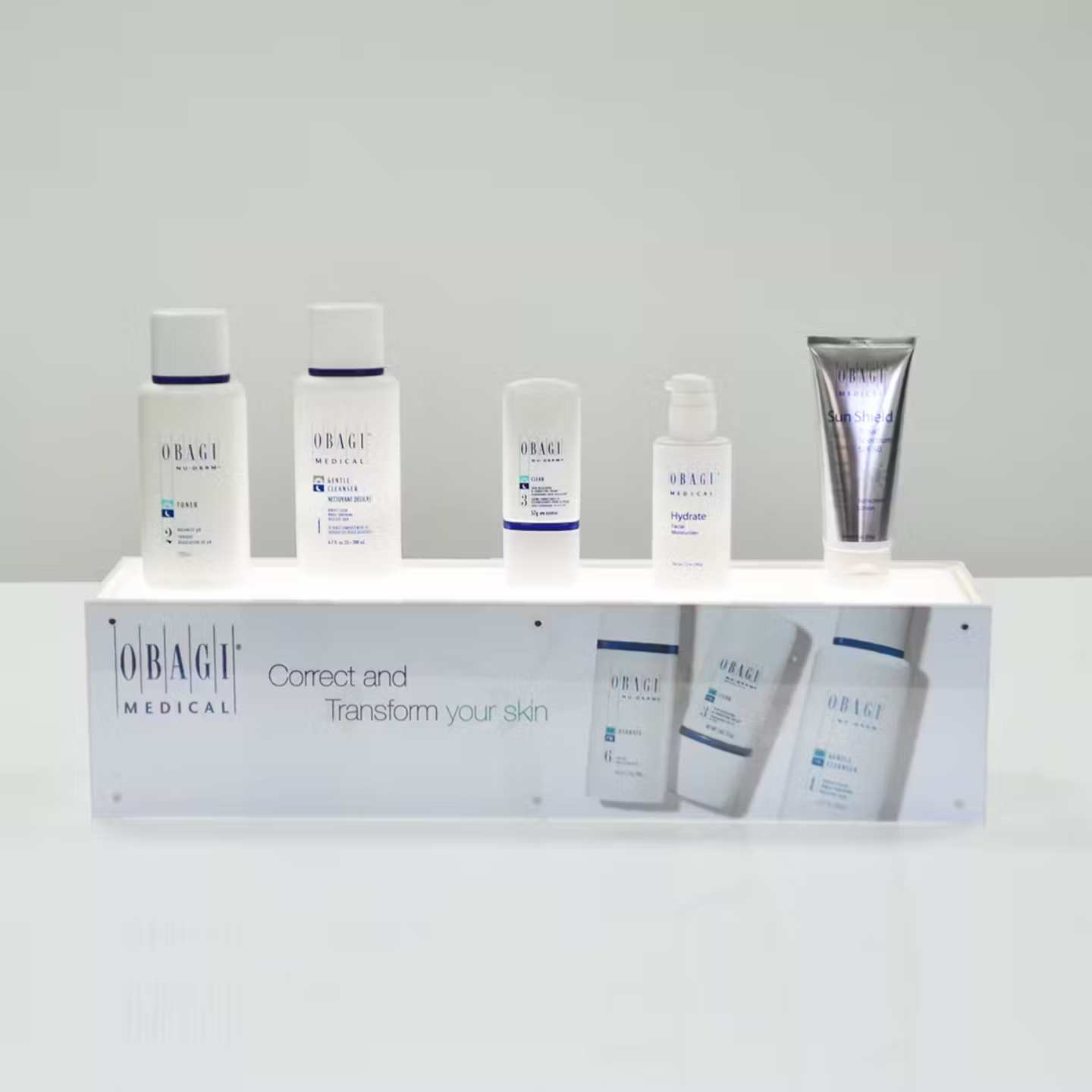 An illuminated countertop plinth with skincare products on top.