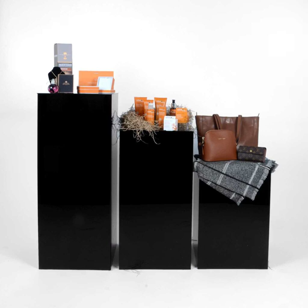 Three black plinths with products placed on top.
