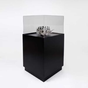 A black display plinth with a decorative object on display.