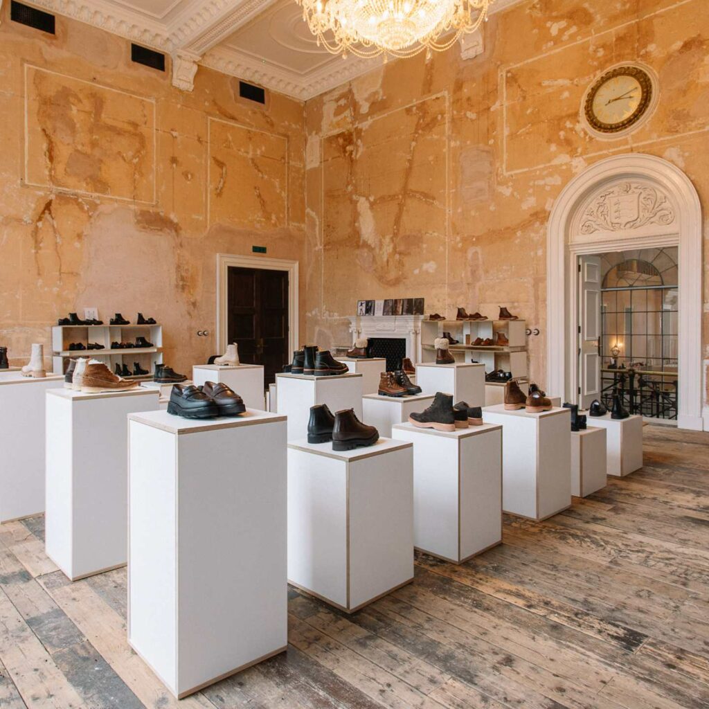 A room filled with white display plinths with products on top.