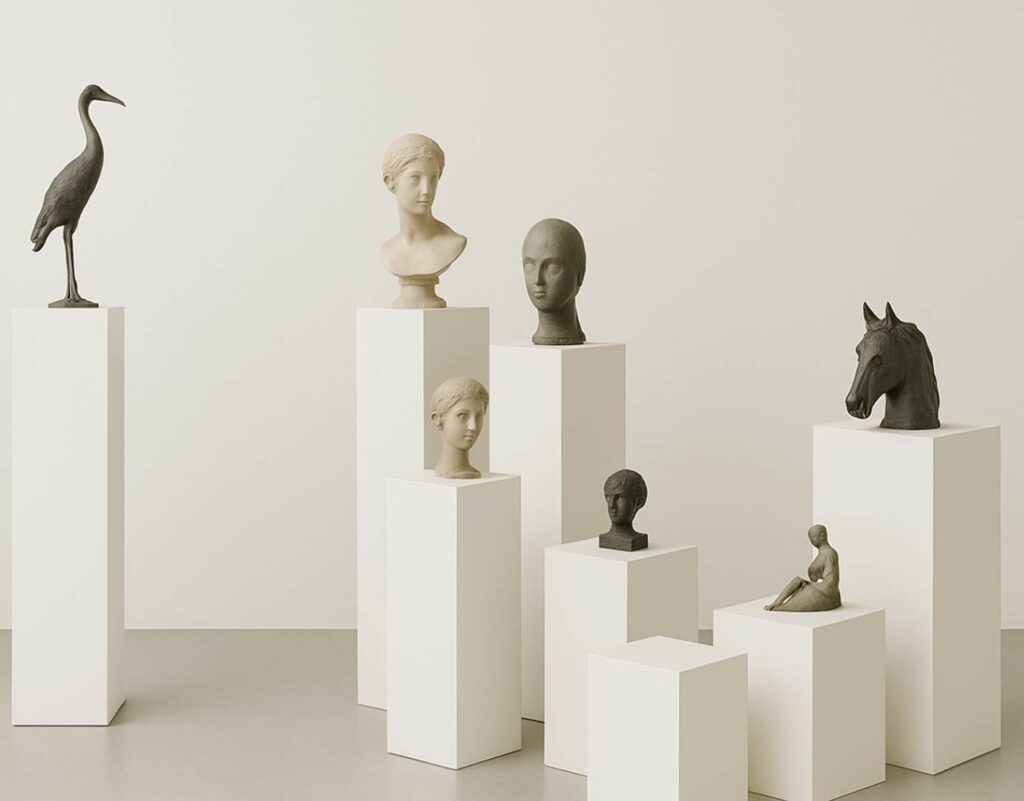 A display of different sized white plinths with sculptures on top.