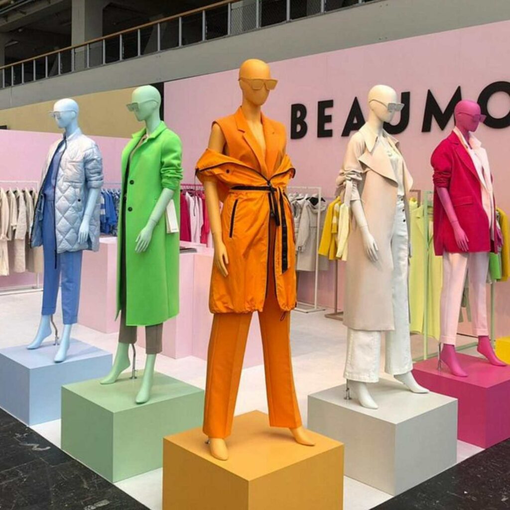 Different coloured plinths with mannequins stood on top.