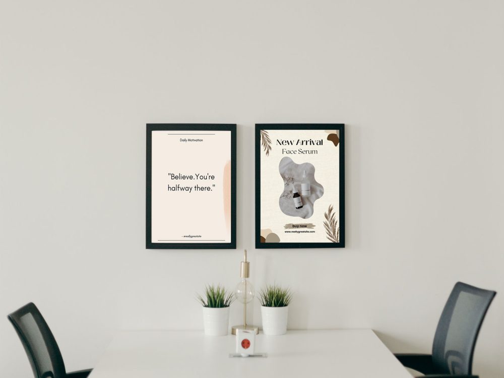 Two black snap frames hanging on a wall above a table and chairs.